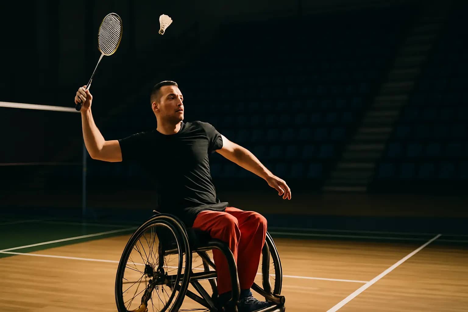 A para badminton player in a wheelchair competing on an indoor court during an international tournament